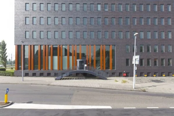 Voorgevel van een modern kantoorgebouw aan de Laan van Zuid Hoorn met verticale houten accenten en een gebogen trap naar de ingang.